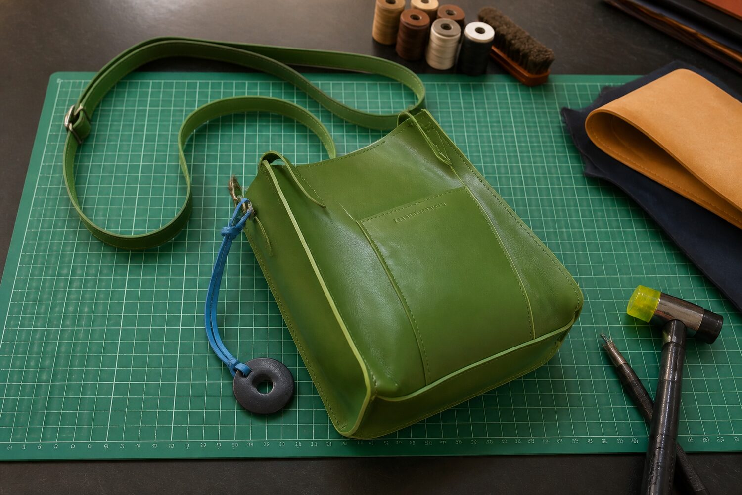 Handmade green leather bag from And Her Son Co. in the workshop